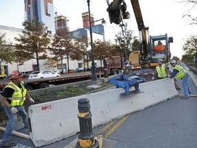 Workers install a concrete barrier along the west side bike path in New York, Thursday, Nov. 2, 2017. New York officials have started putting up additional concrete barriers at intersections, including the one where a terrorist drove a truck onto a bike path, killing eight people. (AP Photo/Seth Wenig)