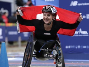 Manuela Schar of Switzerland holds up a flag after crossing the finish line first in the women's wheelchair division of the New York City Marathon in New York, Sunday, Nov. 5, 2017. (AP Photo/Seth Wenig)