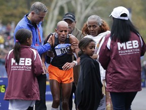 People come to help Meb Keflezighi of the United States, third from left, after collapsed at the finish line of the New York City Marathon in New York, Sunday, Nov. 5, 2017. (AP Photo/Seth Wenig)