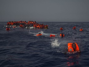 2017 AP YEAR END PHOTOS - African migrants try to reach a rescue boat from the Spanish aid organization Proactiva Open Arms, after falling from a punctured rubber boat in the Mediterranean Sea, about 12 miles north of Sabratha, Libya, on July 23, 2017. (AP Photo/Santi Palacios)