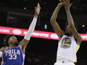 Golden State Warriors' Kevin Durant, right, shoots over Philadelphia 76ers' Robert Covington (33) during the first half of an NBA basketball game Saturday, Nov. 11, 2017, in Oakland, Calif. (AP Photo/Ben Margot)