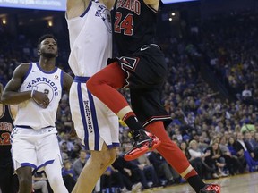 Chicago Bulls forward Lauri Markkanen (24) shoots against Golden State Warriors center Zaza Pachulia during the first half of an NBA basketball game in Oakland, Calif., Friday, Nov. 24, 2017. (AP Photo/Jeff Chiu)