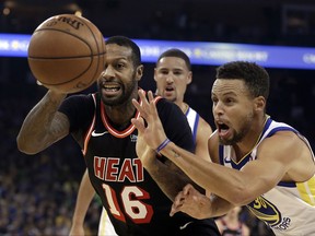 Miami Heat forward James Johnson (16) and Golden State Warriors' Stephen Curry, right, chase a loose ball during the first half of an NBA basketball game Monday, Nov. 6, 2017, in Oakland, Calif. (AP Photo/Ben Margot)