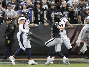 Oakland Raiders wide receiver Michael Crabtree, center, fights with Denver Broncos nose tackle Domata Peko, left, and cornerback Aqib Talib during the first half of an NFL football game in Oakland, Calif., Sunday, Nov. 26, 2017. Crabtree and Talib were ejected. (AP Photo/Ben Margot)