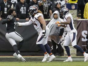 Oakland Raiders wide receiver Michael Crabtree, left, fights with Denver Broncos nose tackle Domata Peko, center, and cornerback Aqib Talib during the first half of an NFL football game in Oakland, Calif., Sunday, Nov. 26, 2017. Crabtree and Talib were ejected. (AP Photo/Ben Margot)
