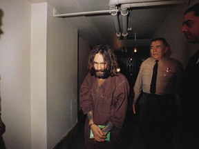In this 1969 file photo, Charles Manson is escorted to court in Los Angeles during an arraignment phase. Authorities say Manson, cult leader and mastermind behind 1969 deaths of actress Sharon Tate and several others, died on Sunday, Nov. 19, 2017. He was 83.