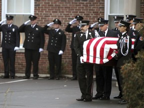 FILE - In this Dec. 31, 2015, file photo, Hamilton, Ohio, firefighters move the casket for Patrick Wolterman into an awaiting fire engine at the Hodapp Funeral Home in Cincinnati. A homeowner and his nephew are scheduled to go on trial in Ohio for murder in a 2015 house fire that resulted in the death of Hamilton firefighter Wolterman. Butler County Judge Greg Stephens said the court should try to seat a jury first. He set jury selection for Monday, Nov. 6. (Cameron Knight/The Cincinnati Enquirer via AP, File)