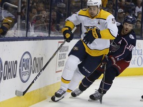 Nashville Predators' Filip Forsberg, left, of Sweden, and Columbus Blue Jackets' Boone Jenner chase a loose puck during the first period of an NHL hockey game Tuesday, Nov. 7, 2017, in Columbus, Ohio. (AP Photo/Jay LaPrete)