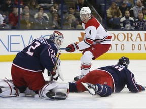 Columbus Blue Jackets' Sergei Bobrovsky, left, of Russia, makes a save as teammate David Savard, right, falls to the ice and Carolina Hurricanes' Haydn Fleury looks for the rebound during the first period of an NHL hockey game Friday, Nov. 10, 2017, in Columbus, Ohio. (AP Photo/Jay LaPrete)