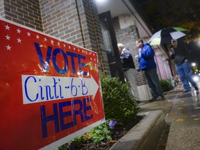 Voters arrive at a polling station, Tuesday, Nov. 7, 2017, in downtown Cincinnati. Ohio voters will decide ballot issues on Tuesday that would place limits on drug prices and expand victims' rights in criminal proceedings, along with several mayoral races. (AP Photo/John Minchillo)