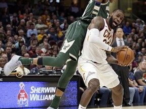 Cleveland Cavaliers' LeBron James, right, is fouled by Milwaukee Bucks' Giannis Antetokounmpo, from Greece, in the first half of an NBA basketball game, Tuesday, Nov. 7, 2017, in Cleveland. (AP Photo/Tony Dejak)