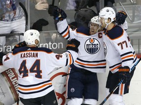 Connor McDavid, centre, celebrates with Edmonton Oilers teammates Zack Kassian, left, and Oscar Klefbom after he scored the game-winning goal in overtime against the Islanders in New York on Tuesday night.