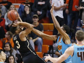 Charlotte guard Jon Davis (3) shoots as Oklahoma State forward Lucas N'Guessan (14) defends during the first half of an NCAA college basketball game in Stillwater, Okla., Monday, Nov. 13, 2017. (AP Photo/Sue Ogrocki)