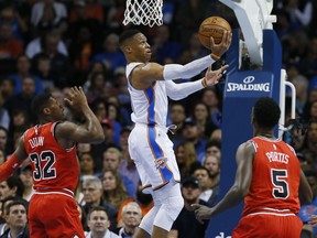 Oklahoma City Thunder guard Russell Westbrook, center, shoots between Chicago Bulls guard Kris Dunn (32) and forward Bobby Portis (5) in the first quarter of an NBA basketball game in Oklahoma City, Wednesday, Nov. 15, 2017. (AP Photo/Sue Ogrocki)