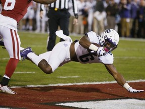 TCU running back Darius Anderson (6) dives into the end zone for a touchdown in front of Oklahoma defender Tre Brown, left, in the first quarter of an NCAA college football game in Norman, Okla., Saturday, Nov. 11, 2017. (AP Photo/Sue Ogrocki)
