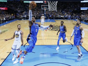 Oklahoma City Thunder guard Russell Westbrook (0) goes up for a shot in front of Golden State Warriors guard Stephen Curry (30) and Thunders' Jerami Grant (9) and Steven Adams (12) during the first quarter of an NBA basketball game in Oklahoma City, Wednesday, Nov. 22, 2017. (AP Photo/Sue Ogrocki)