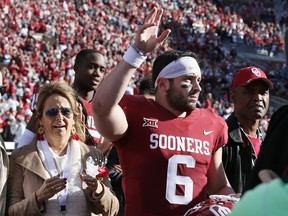 Oklahoma quarterback Baker Mayfield (6) waves to the crowd as he is announced on Senior Day, before the West Virginia-Oklahoma NCAA college football game in Norman, Okla., Saturday, Nov. 25, 2017. At left is his mom, Gina Mayfield. (AP Photo/Sue Ogrocki)