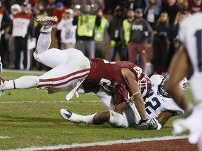 Oklahoma running back Rodney Anderson, left, tumbles into the end zone with TCU linebacker Travin Howard, right, for a touchdown in the second quarter of an NCAA college football game in Norman, Okla., Saturday, Nov. 11, 2017. (AP Photo/Sue Ogrocki)