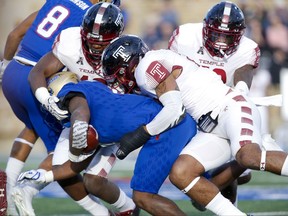 Tulsa's D'Angelo Brewer (4) is tackled by Temple defenders during the first half of an NCAA college football game Saturday, Nov. 25, 2017, in Tulsa, Okla. (Jessie Wardarski/Tulsa World via AP)