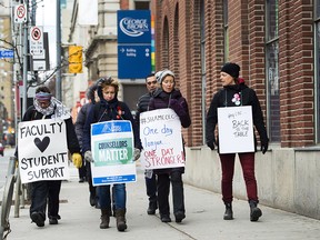 Teachers and faculty staff of the Ontario Public Service Employees Union walk the picket line at George Brown College in Toronto on November 16, 2017. College faculty in Ontario head back to their schools today to prepare for students' return on Tuesday.