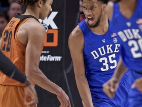 Duke forward Marvin Bailey III, right, reacts after dunking over Texas forward Jericho Sims during the first half of an NCAA college basketball game in the Phil Knight Invitational tournament in Portland, Ore., Friday, Nov. 24, 2017. (AP Photo/Craig Mitchelldyer)