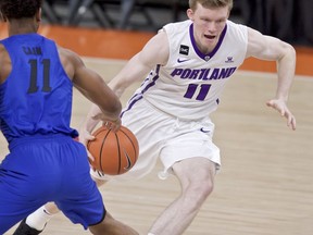 Portland guard Josh McSwiggan, right, dribbles past DePaul guard Eli Cain during the first half of an NCAA college basketball game in the Phil Knight Invitational tournament in Portland, Ore., Sunday, Nov. 26, 2017. (AP Photo/Craig Mitchelldyer)