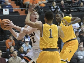 Oregon State's Drew Eubanks looks for an open teammate as Wyoming's Justin James (1) and a teammate defend during an NCAA college basketball game Monday, Nov. 13, 2017, in Corvallis, Ore. (Andy Cripe/The Corvallis Gazette-Times via AP)