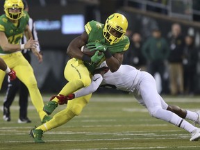 Oregon running back Royce Freeman, center left, is tackled by Arizona's Gavin Robertson Jr. during the first quarter of an NCAA college football game, Saturday, Nov. 18, 2017, in Eugene, Ore. (AP Photo/Chris Pietsch)