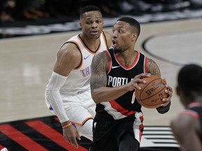 Portland Trail Blazers guard Damian Lillard, right, looks to pass as Oklahoma City Thunder guard Russell Westbrook defends during the first half of an NBA basketball game in Portland, Ore., Sunday, Nov. 5, 2017. (AP Photo/Steve Dipaola)