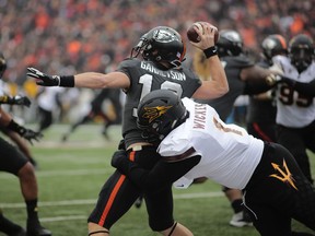 Oregon State quarterback Darell Garreston (10) is hit by Arizona State's JoJo Wicker (1) in the first half of an NCAA college football game, in Corvallis, Ore., Saturday, Nov. 18, 2017. Garretson was penalized for intentional grounding while in the end zone, resulting in a safety. (AP Photo/Timothy J. Gonzalez)