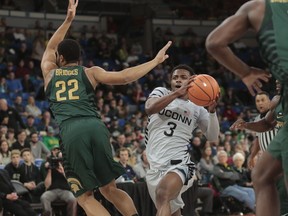 Connecticut's Alterique Gilbert (3) drives to the basket past Michigan State's Miles Bridges (22) during the first half of an NCAA college basketball game during the Phil Knight Invitational tournament in Portland, Ore., Friday, Nov. 24, 2017. (AP Photo/Timothy J. Gonzalez)
