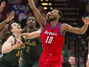 DePaul forward Tre'Darius McCallum, right, grabs a rebound away from Michigan State guard Conner George, left, during the first half in an NCAA college basketball game at the Phil Knight Invitational tournament in Portland, Ore., Thursday Nov. 23, 2017. (AP Photo/Troy Wayrynen)