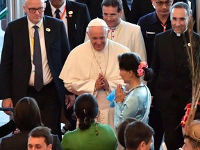 Pope Francis, center, is greeted by by Myanmar's leader Aung San Suu Kyi, center, as he arrives to deliver his speech to members of the diplomatic corps and local authorites, in the International Convention Center, in Naypyitaw, Myanmar, Tuesday, Nov. 28, 2017.