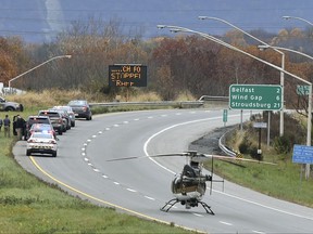 Emergency personal respond to the scene where a Pennsylvania State Police corporal was shot in Northampton County, Pa., Tuesday, Nov. 7, 2017. The corporal was shot several times while exchanging gunfire with a suspect during a traffic stop Tuesday morning, and the suspect was also wounded, authorities said. (April Gamiz/The Morning Call via AP)