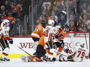 Calgary Flames' Sean Monahan, left, reacts to his second goal during the second period of an NHL hockey game against the Philadelphia Flyers, Saturday, Nov. 18, 2017, in Philadelphia. The Flames won 5-4 in overtime. (AP Photo/Chris Szagola)