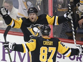 Pittsburgh Penguins' Phil Kessel (81) celebrates his goal with Sidney Crosby (87) during the first period of an NHL hockey game against the Tampa Bay Lightning in Pittsburgh, Saturday, Nov. 25, 2017. (AP Photo/Gene J. Puskar)
