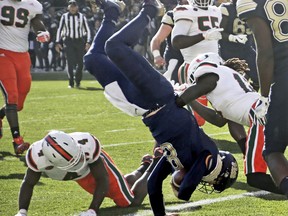 Pittsburgh quarterback Kenny Pickett (8) flips over Miami defensive back Jaquan Johnson (4) as he goes in for a touchdown in the first half of an NCAA college football game, Friday, Nov. 24, 2017, in Pittsburgh. (AP Photo/Keith Srakocic)