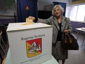 A woman votes in a polling station in Palermo, Sicily, Italy, Sunday,  Nov. 5 2017. More than 4.6 million voters in Sicily are heading to the polls Sunday to pick a new regional governor in the last important vote before a national election early next year. (Michele Naccari/ANSA via AP)