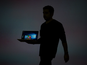 The silhouette of Panos Panay is seen as he unveils a Microsoft Surface Book laptop