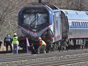 FILE - In this April 3 2016, file photo, Amtrak investigators inspect the deadly train crash in Chester, Pa. The Amtrak train struck a piece of construction equipment just south of Philadelphia causing a derailment. The National Transportation Safety Board is set to review the findings of an investigation into what caused a speeding Amtrak train to slam into a backhoe last year near Philadelphia, killing two maintenance workers. The board is meeting Tuesday, Nov. 14, 2017, in Washington to determine a probable cause of the deadly crash. (Michael Bryant/The Philadelphia Inquirer via AP, File)