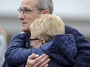 Steffan and Lisa Shaw, parents of slain New Kensington Police Officer Brian Shaw, watch while the casket with the body of their son is moved into the Rusiewicz Funeral in Lower Burrell, Pa., Saturday, Nov. 18, 2017. Shaw was shot in the chest Friday night in New Kensington, northeast of Pittsburgh. The shooting occurred during a foot chase that began shortly after the traffic stop took place. (Pam Panchak/Pittsburgh Post-Gazette via AP)