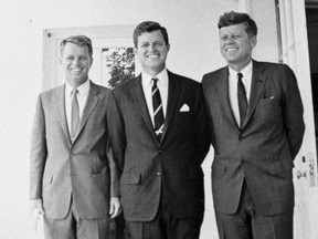 FILE - In this Aug.23, 1963, file photo, Sen. Edward M. Kennedy, D-Mass., center, poses with his brothers U.S. Attorney General Robert F. Kennedy, left, and President John F. Kennedy at the White House in Washington. The Cape Cod Times reported Nov. 27, 2017, that a hockey stick featuring the signatures of the three Kennedy brothers is now on display at a Cape Cod museum. (AP Photo/File)