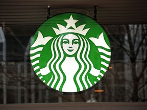 FILE - This Thursday, Jan. 12, 2017, file photo shows a Starbucks logo sign in the window of one of the chain's cafes in Pittsburgh. Starbucks is kicking off its holiday season by offering two holiday drinks for the price of one for three hours a day from Nov. 9 to 13. (AP Photo/Gene J. Puskar, File)