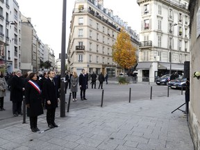 French President Emmanuel Macron and Paris mayor Anne Hidalgo, left, stand in front of a commemorative plaque facing the 'Le Carillon' bar and 'Le Petit Cambodge' restaurant during a ceremony marking the second anniversary of the Paris attacks, Monday Nov.13 November 2017. Macron, Paris Mayor Anne Hidalgo and victims' families are paying homage to 130 people killed two years ago when Islamic State extremists attacked the City of Light. (Etienne Laurent, Pool via AP)