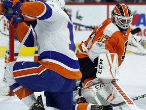 New York Islanders' Matthew Barzal, left, gets the puck past Philadelphia Flyers' Brian Elliott and scores during the first period of an NHL hockey game, Friday, Nov. 24, 2017, in Philadelphia. (AP Photo/Tom Mihalek)