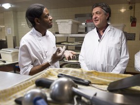 Filippo Grandi, the UN high commissioner for refugees, right, meets with Jean-Claude Puati, 40, a refugee from the Democratic Republic of Congo, while at work in a hospital cafeteria Friday, November 3, 2017 in Montreal. THE CANADIAN PRESS/Paul Chiasson
