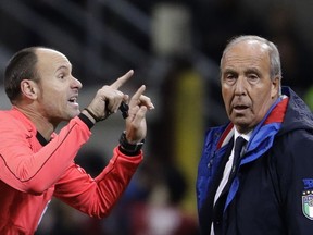 Referee Antonio Mateu Lahoz of Spain gestures when talking to Italy coach Gian Piero Ventura during the World Cup qualifying play-off second leg soccer match between Italy and Sweden, at the Milan San Siro stadium, Italy, Monday, Nov. 13, 2017. (AP Photo/Luca Bruno)