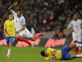 Brazil's Casemiro's tackle sends England's Ryan Bertrand flying during the international friendly soccer match between England and Brazil at Wembley stadium in London, Britain, Tuesday, Nov. 14, 2017. (AP Photo/Alastair Grant)