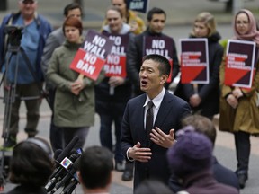 FILE - In this May 15, 2017, file photo, Hawaii Attorney General Doug Chin, center, talks to reporters outside a federal courthouse in Seattle. A U.S. appeals court on Monday, Nov. 13, allowed President Donald Trump's newest version of the travel ban to partially take effect. The decision "closely tracks guidance previously issued by the Supreme Court," Chin said in a statement. "I'm pleased that family ties to the U. S., including grandparents, will be respected. We continue to prepare for substantive arguments before the Ninth Circuit on December 6 in Seattle." (AP Photo/Ted S. Warren, File)