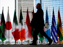 A man walks past the flags of participating countries at the 2017 United Nations Peacekeeping Defence Ministerial conference in Vancouver on Tuesday.